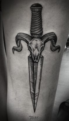 a black and white photo of a tattoo with a dagger in the shape of a goat head