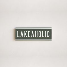 a green and white street sign that says lakeaholic on the side of a wall