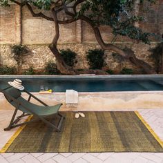 a chair sitting on top of a rug next to a pool