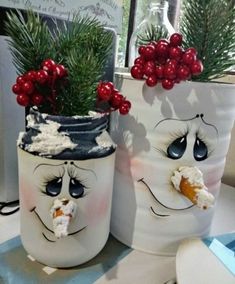 two white pots with faces painted on them