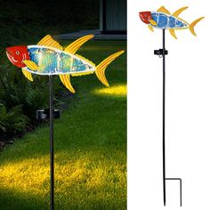 two fish are on the ground next to a lamp in the grass and one has its head turned upside down