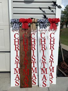 two wooden christmas signs with red bows on them