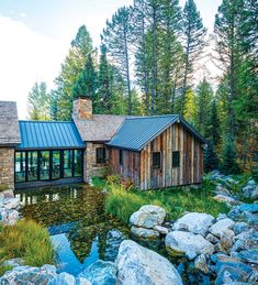 a house with a pond in front of it and lots of rocks on the ground