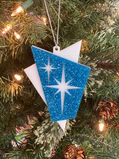 a blue and white ornament hanging from a christmas tree