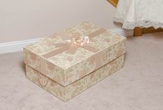 two boxes are sitting on the floor in front of a bed and carpeted area