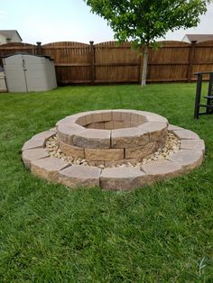 a fire pit in the middle of some grass