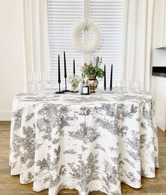 the table is set with candles, flowers and wine glasses in front of the window