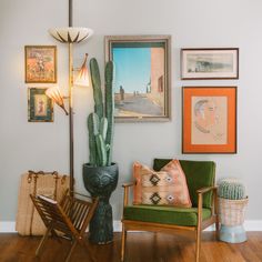 a living room filled with furniture and pictures on the wall next to a cactus plant