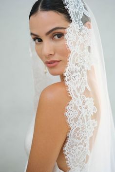 a woman wearing a veil with lace on it