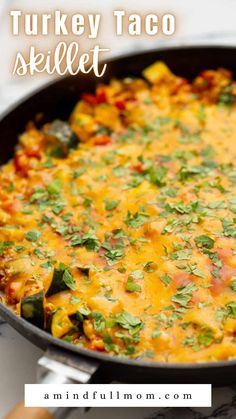 a skillet filled with turkey taco casserole and topped with cilantro