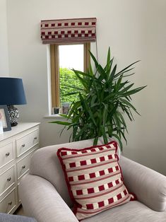 a living room with a chair, lamp and potted plant