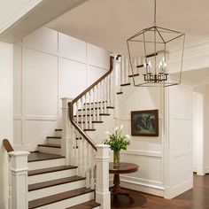 a foyer with white walls and wood floors