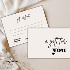 two cards with the words gift for you written in black ink on them, next to a bouquet of flowers