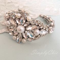 Beautiful Bridal Bracelet . Made with Crystals and pearls set in rhodium plated metal. This bracelet is about 1 1/4 inches wide . It is an open bangle so it will fit any size. Pearls are available in white and ivory. the pictures are taken with ivory pearls. Matching earrings are available at this link: https://www.etsy.com/listing/721180019/vintage-pearl-rhinestone-drop-earrings?ref=shop_home_active_1 Matching hair comb: https://www.etsy.com/listing/703183928/vintage-oval-shape-crystal-rhinesto Elegant Silver Beaded Cuff Bracelet, White Pearl Bangle For Wedding, Elegant White Pearl Bangle For Wedding, Elegant Beaded Cuff Bracelet For Wedding, Silver Beaded Bracelets For Wedding, Silver Beaded Bangle Bracelets For Wedding, Silver Beaded Pearl Bangle Bracelet, Silver Bangle Pearl Bracelet For Weddings, Silver Pearl Bangle For Wedding