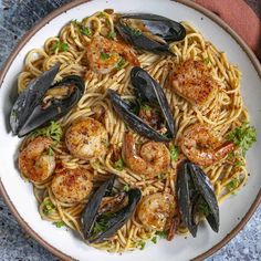 a plate of pasta with shrimp and mussels