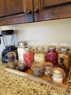 a wooden tray filled with lots of food on top of a counter next to a blender