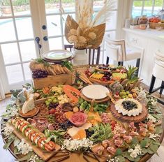 a table covered in lots of different types of food on top of a wooden table