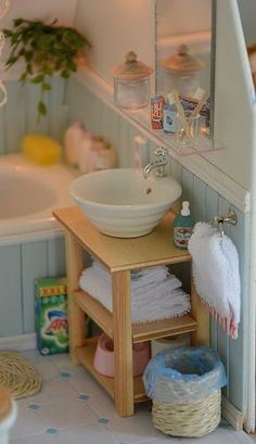 a doll house bathroom with sink, mirror and bathtub