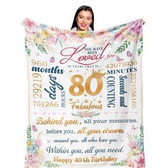 a woman holding up a birthday blanket with the words 80th birthday printed on it