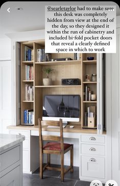 a desk with a computer on top of it in front of a book shelf filled with books