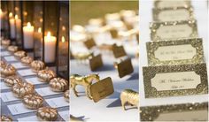 gold and white place cards are on the table next to each other, with candles in the background