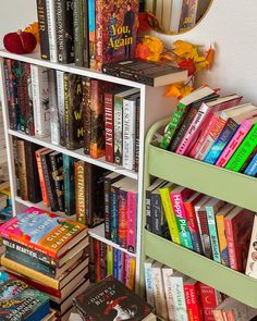 a book shelf filled with books next to a mirror