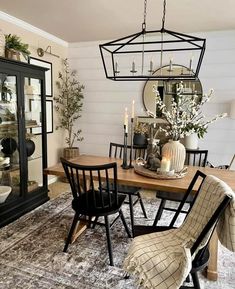 a dining room table with chairs and a chandelier hanging from it's ceiling