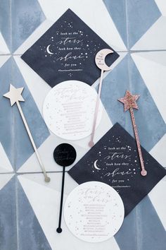 two black and white paper fans, one with a star on the top and one with a moon on the bottom