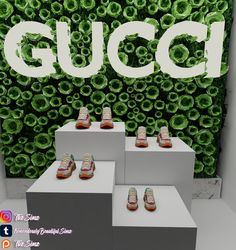 there are three pairs of shoes on display in front of a gucci wall sign