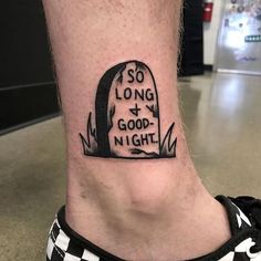 a black and white photo of a person's foot with a tattoo saying so long good night