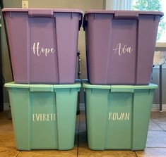 three purple and green containers with names on them sitting next to each other in front of a window