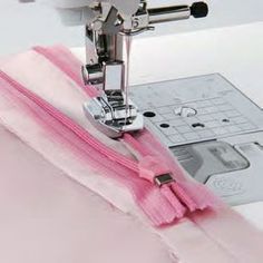 the sewing machine is working on the pink fabric