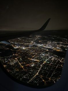 the view from an airplane window at night, looking down on a cityscape