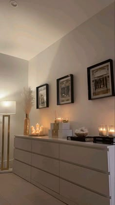 a living room with candles and pictures on the wall