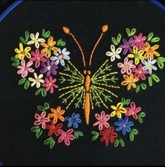 an embroidered butterfly with colorful flowers on it's wings is shown in the shape of a circle