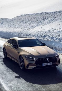 the mercedes amg coupe is driving on a snowy road