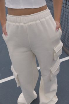 Stay comfortable in style with these Sporty Spice Cream Fleece Sweatpants. Made of butter-soft fleece fabric in a relaxed fit, these sweatpants are perfect for lounging or exercising. Delightful features include a high waist and two mini pockets on the sides. Move with confidence in comfy confidence and style. butter soft relaxed fit high waist mini side pockets cream 80% polyester 20% cotton model is wearing a small Casual Pants With Pockets For Relaxation, Casual Sweatpants With Soft Texture For Relaxation, Comfortable Sweatpants With Pockets For Relaxation, Winter Loungewear Joggers With Cargo Pockets, Sporty Cargo Pants With Elastic Waistband For Loungewear, Sporty Bottoms With Pockets For Relaxation, Casual Bottoms With Pockets For Relaxation, Trendy Fleece Sweats With Elastic Waistband, Trendy Cargo Pocket Sweatpants For Loungewear