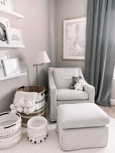 a baby's room with a chair, ottoman and pictures on the wall above it