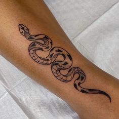 a black and white snake tattoo on the arm