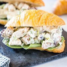 a chicken salad sandwich is on a black plate