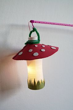 a red and green light hanging from a white wall