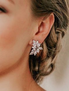 a close up of a person wearing some kind of earring with flowers on it