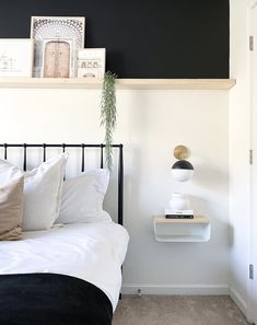 a bedroom with black and white decor on the headboard, bedding, and shelves