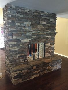 a stone fireplace in the middle of a living room