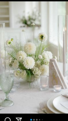 the table is set with white flowers and candles