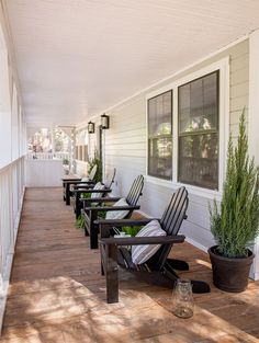 a row of chairs sitting on top of a wooden porch