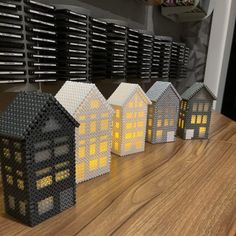 small lego houses sitting on top of a wooden table