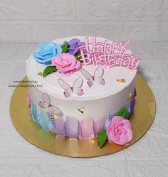 a birthday cake decorated with butterflies and flowers