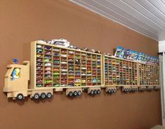 a toy truck is hanging on the wall next to a shelf filled with cars and other toys