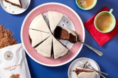 slices of cake sitting on top of plates next to cups and spoons with coffee in them